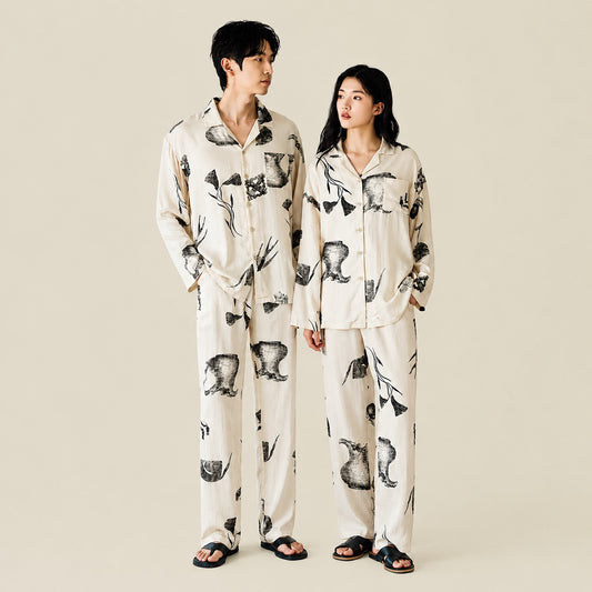 Couple wearing matching Ink Still Life Bamboo Pajama Sets standing indoors