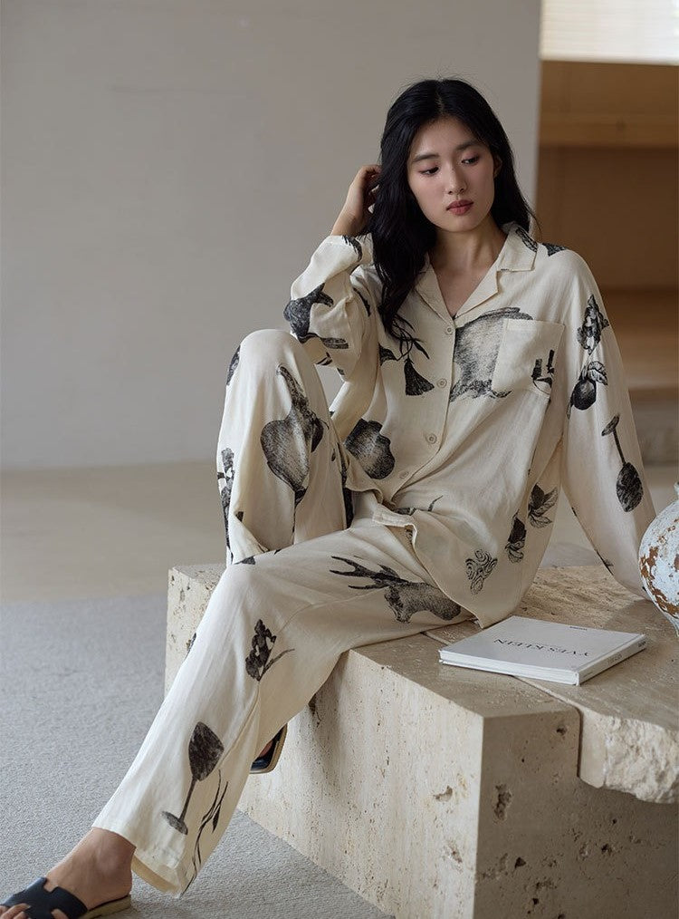 Woman wearing the Ink Still Life Bamboo Pajama Set seated indoors in a relaxed pose